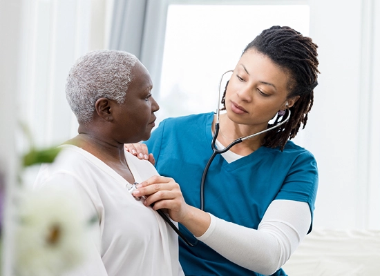 Provider listening to patient's chest with stethoscope